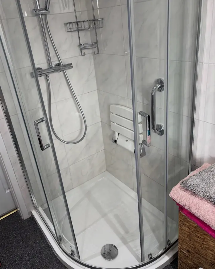 A shower cubicle with clear glass and a clean tray